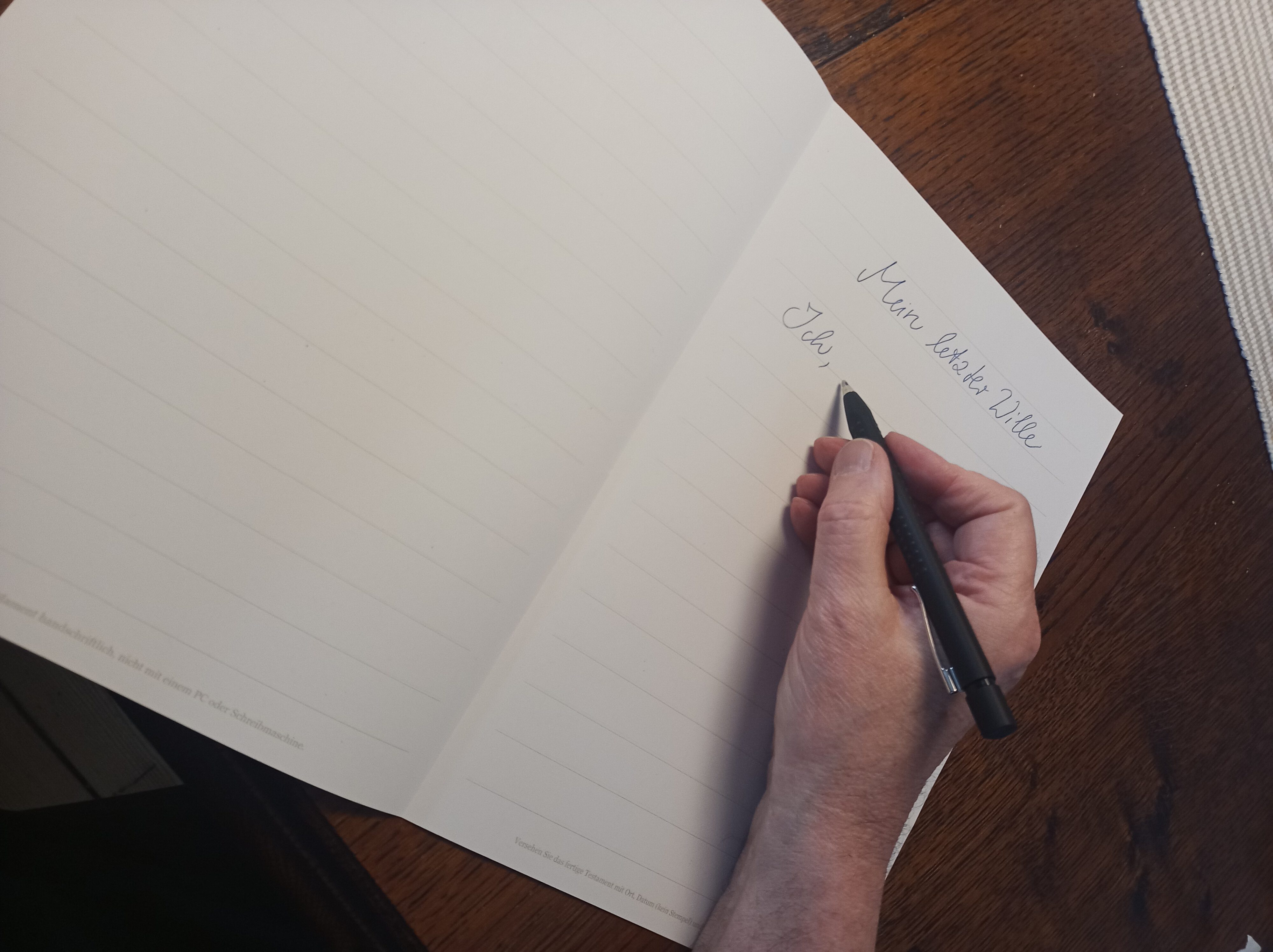 Person beim Schreiben eines Testaments